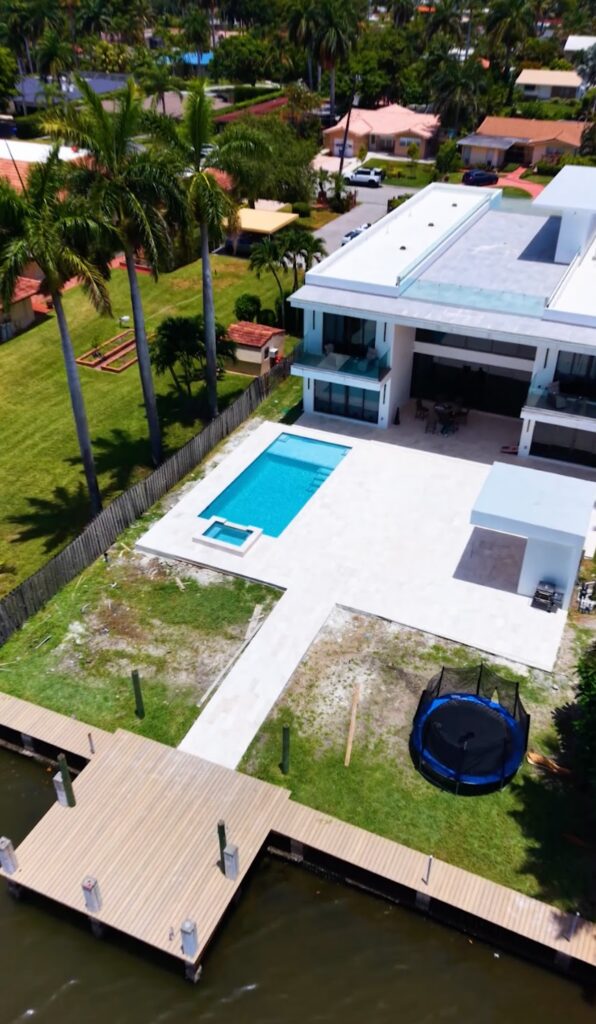 Aerial view of a waterfront home with a new pool, deck and dock