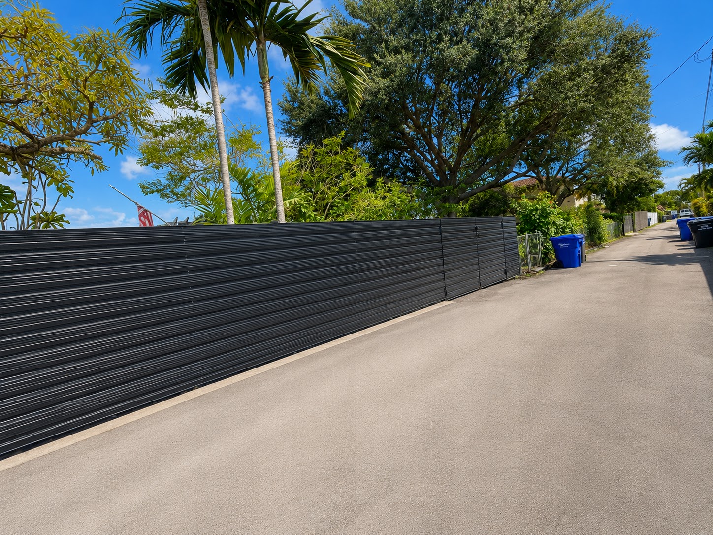 Black horizontal aluminum privacy fence along a residential driveway in South Florida, installed by Canet Group