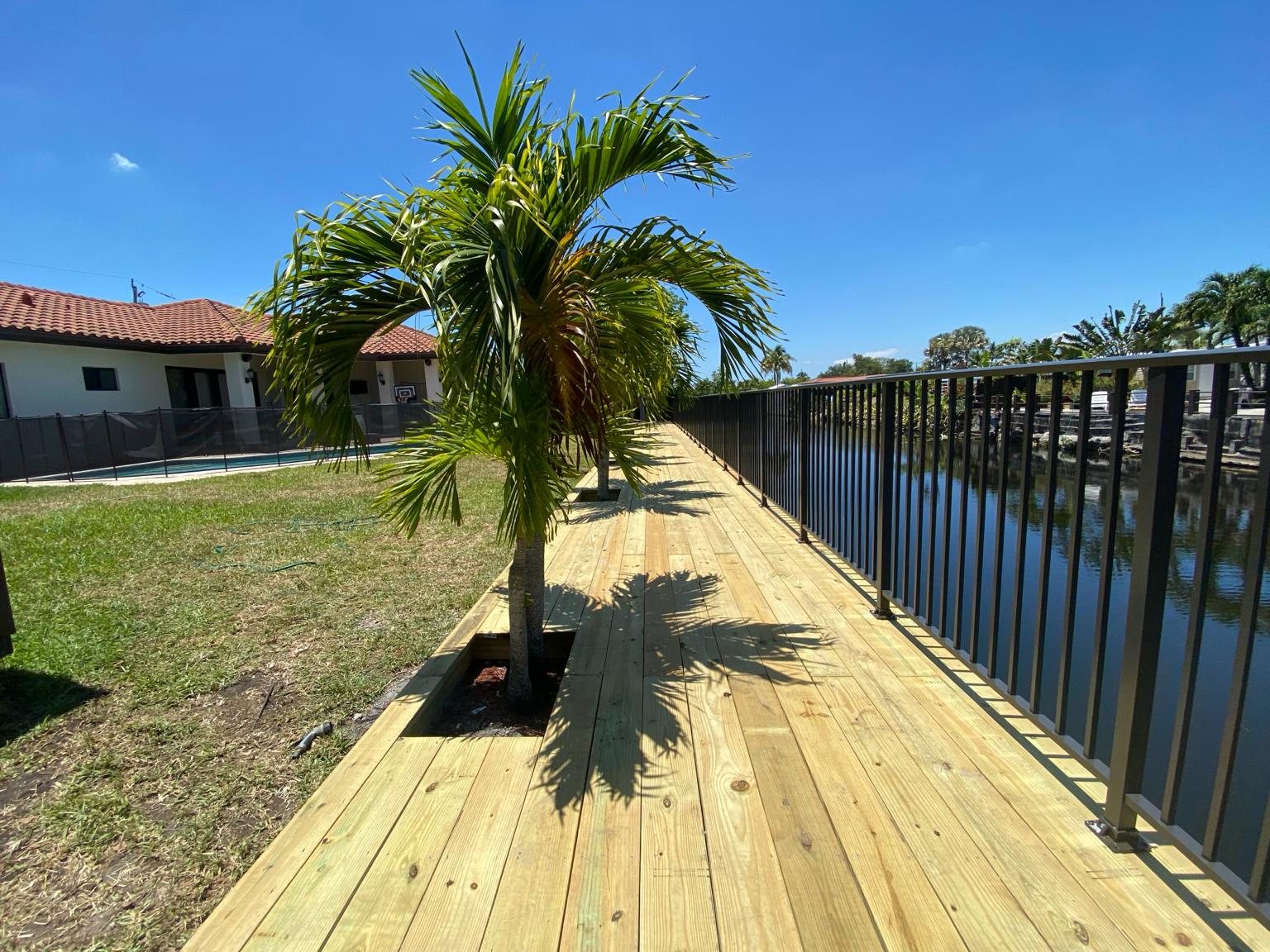 Long backyard wood deck with palm trees built by Canet Group