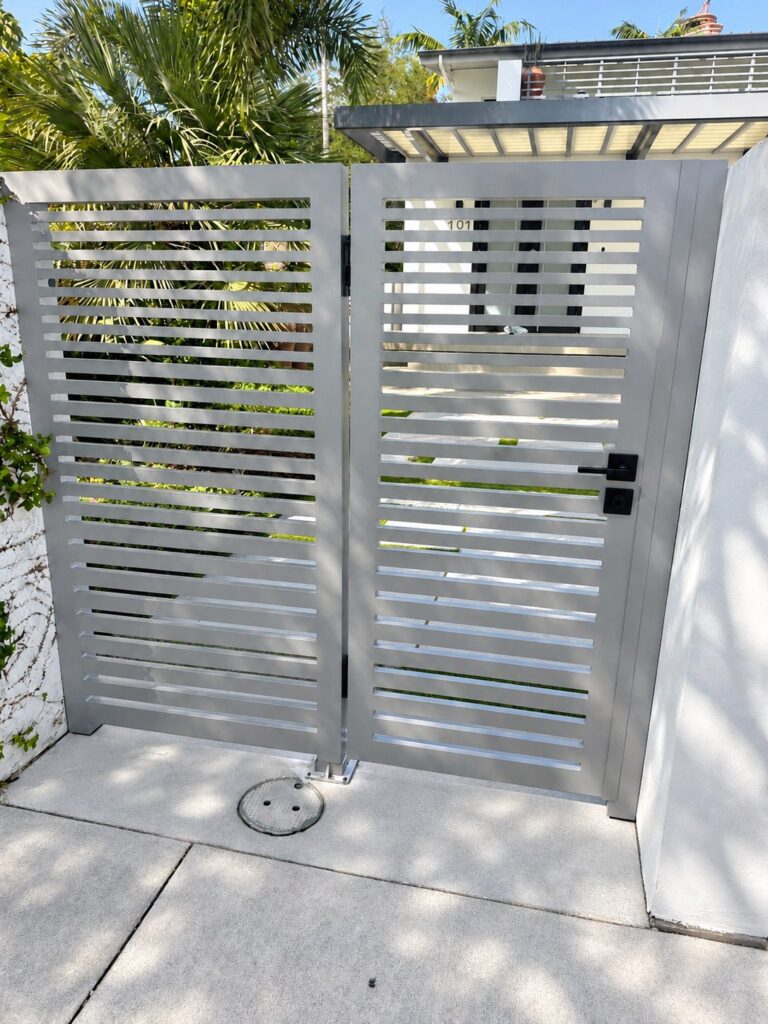 Gray horizontal aluminum slat double gate with black hardware, built by Canet Group