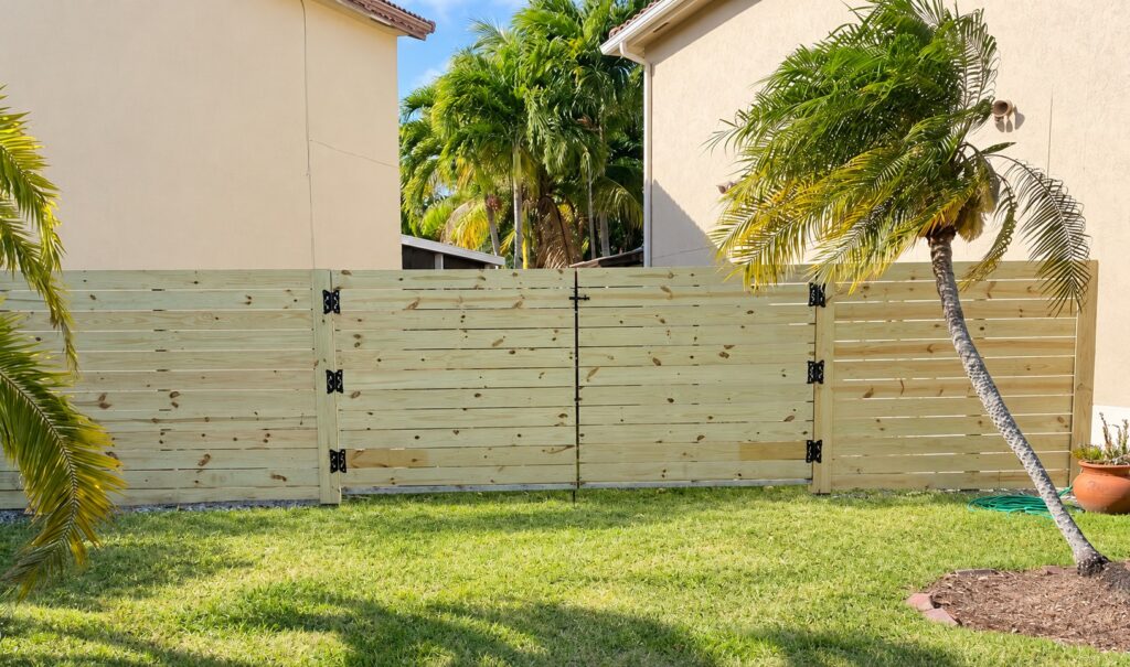 Pine horizontal wood privacy fence with a gate, installed by Canet Group