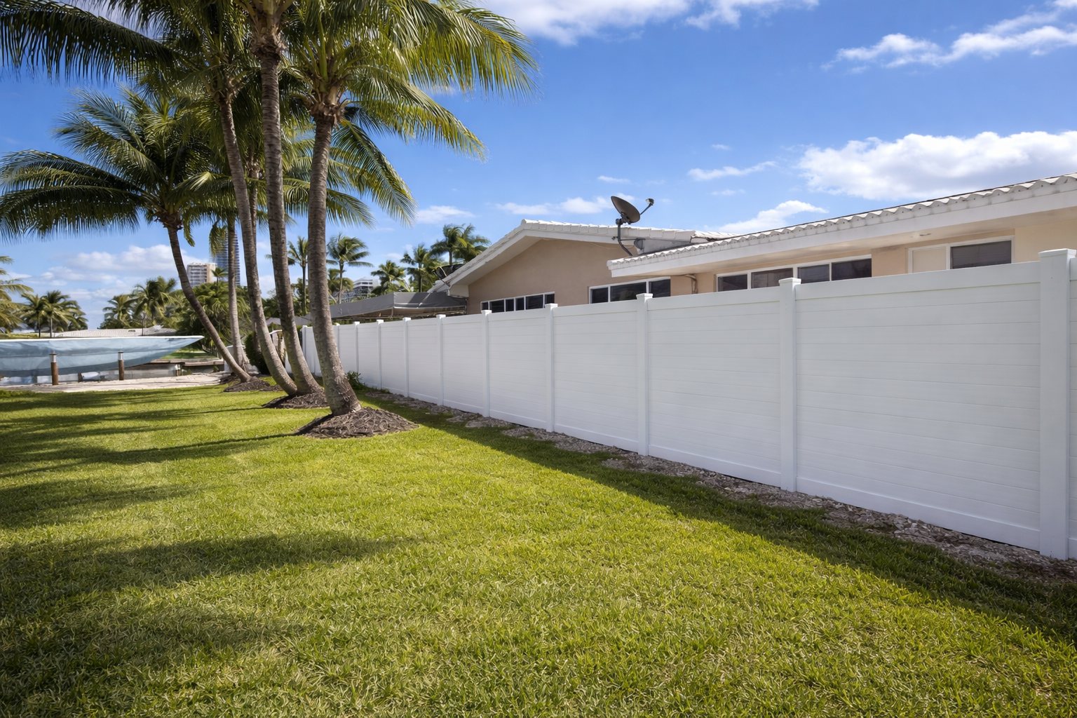 White vinyl PVC privacy fence around a backyard with palm trees, installed by Canet Group