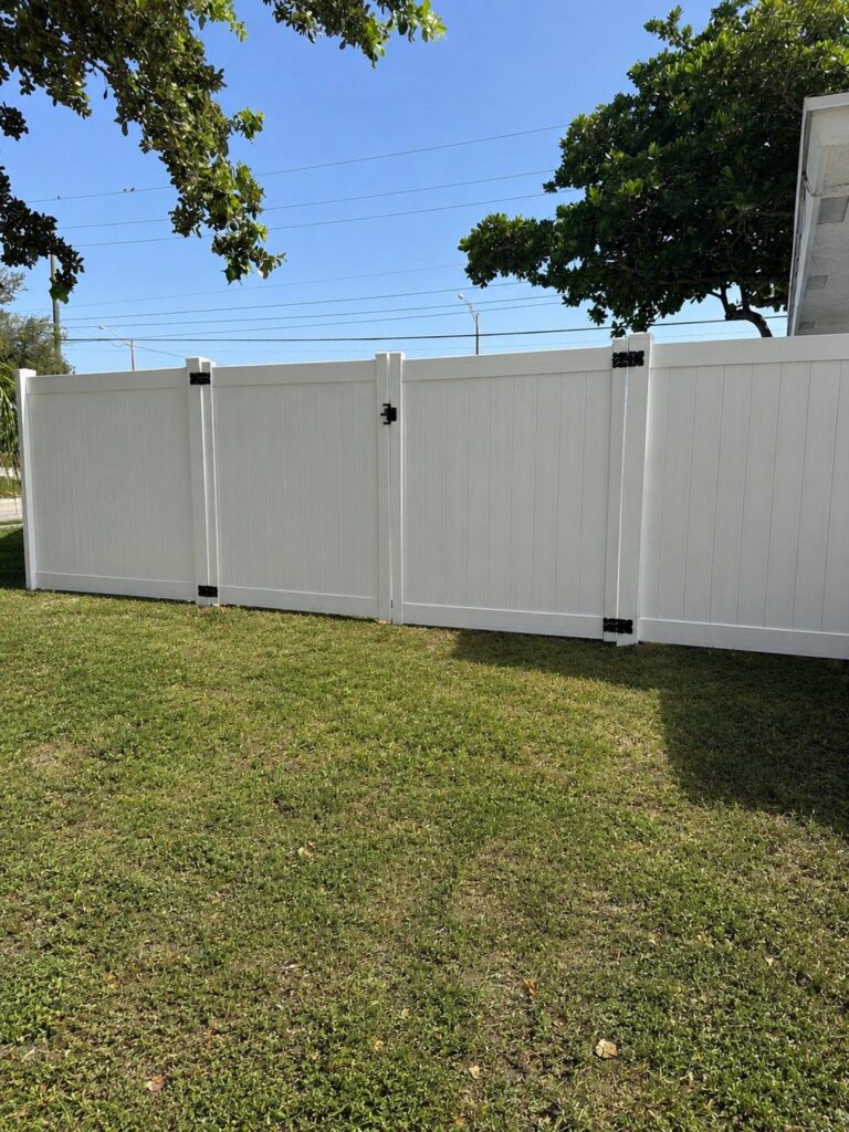 White vinyl privacy fence with a matching gate installed by Canet Group