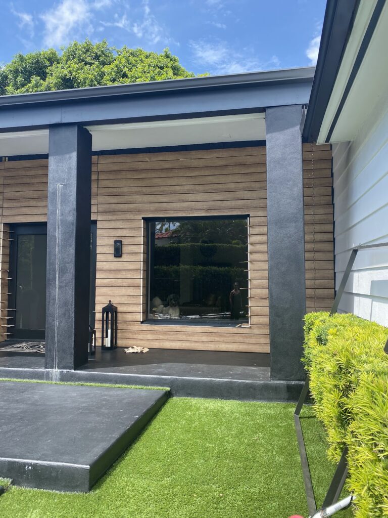 Modern home exterior with wood-look slat cladding and black trim
