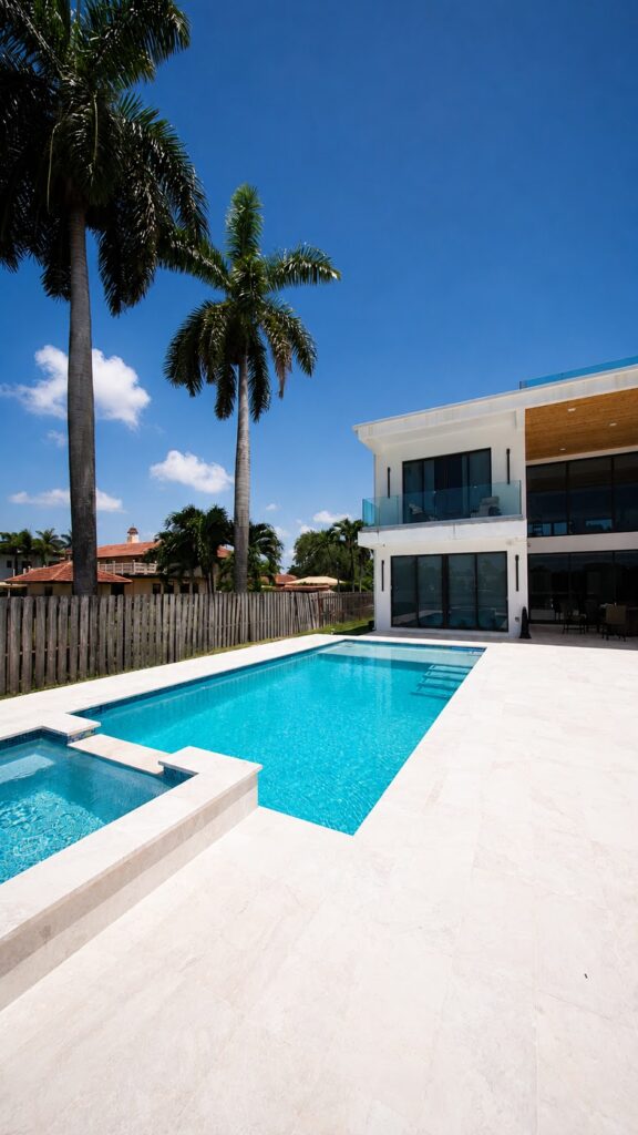 Modern home with a new pool and spa framed by palm trees