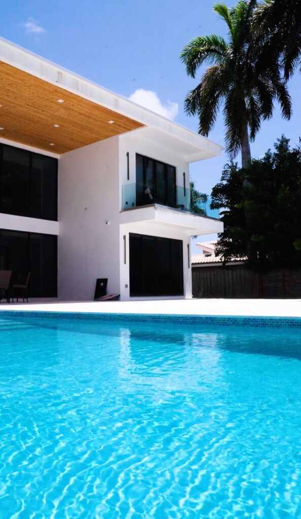 New pool built along a modern two-story home with a wood soffit in Miami