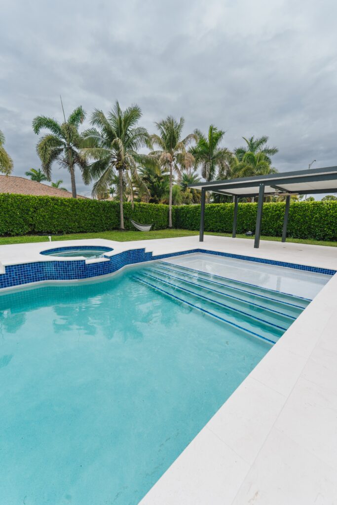 Backyard with pool, new pool deck and modern aluminum pergola in South Florida