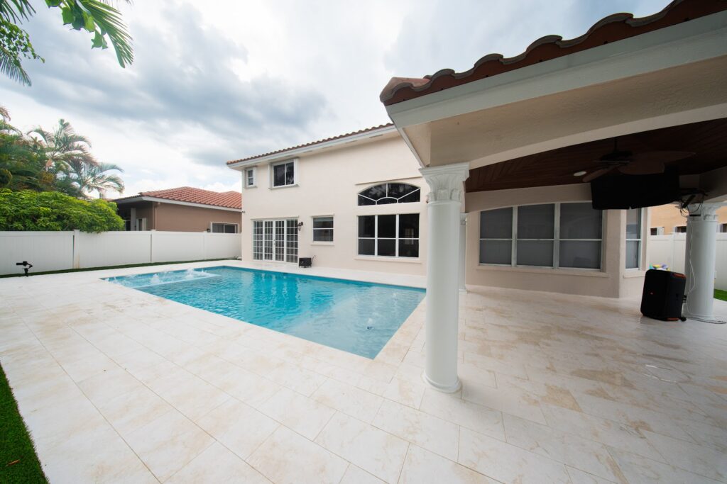 Renovated pool with a new deck next to a covered patio