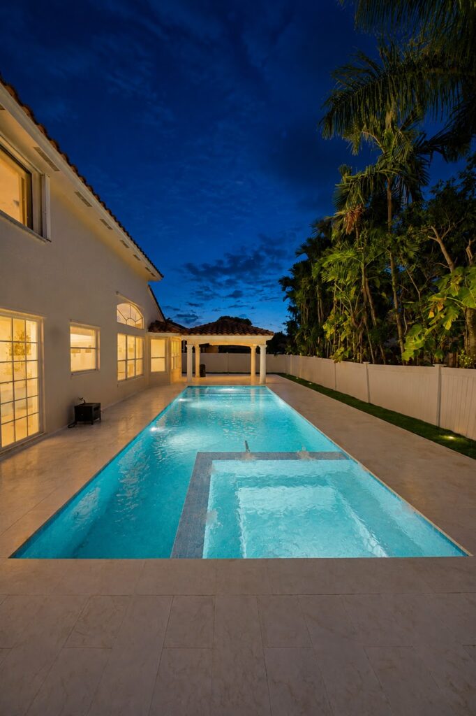 Pool renovation with new interior finish, coping and spa at dusk